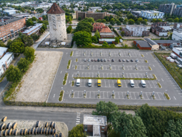 Zentraler Betriebshof mit Ladeinfrastruktur und Wasserturm mit modernen Büro- und Lagerflächen - Luftbild (KI)
